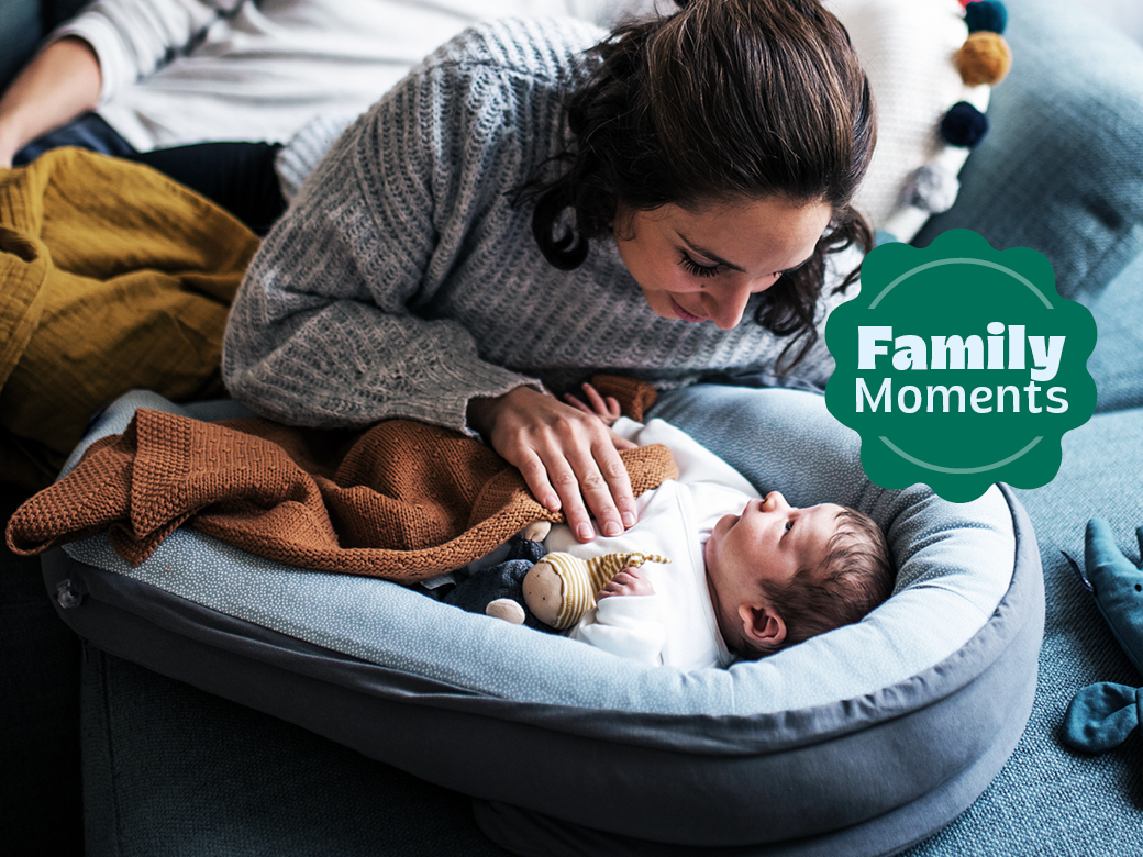 Mutter mit Neugeborenem in einem Nestchen