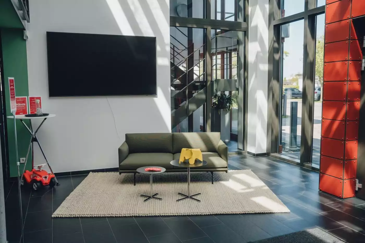 Wohnzimmer ein mit einer grünen couch und einem fernseher.