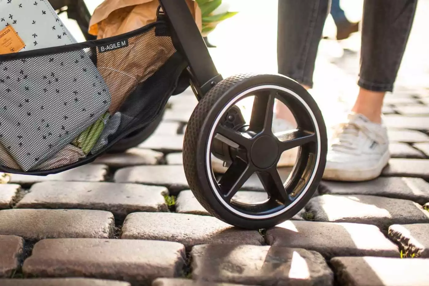 Person eine schieben einen spaziergang mit einer tasche darauf.