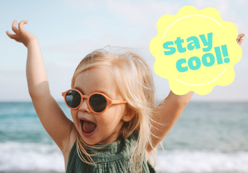 Stay cool! Kind mit Sonnenbrille im Kleid am Meer.