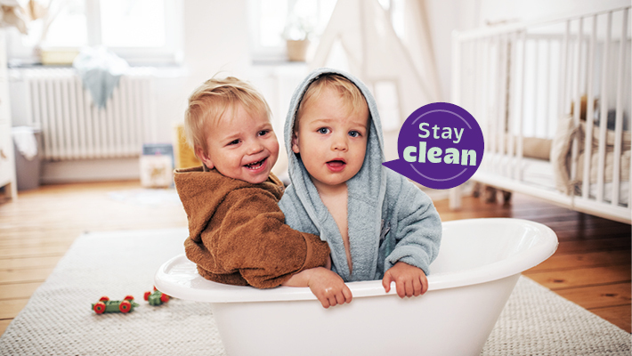 Zwei Babys sitzen in einer kleinen Badewanne