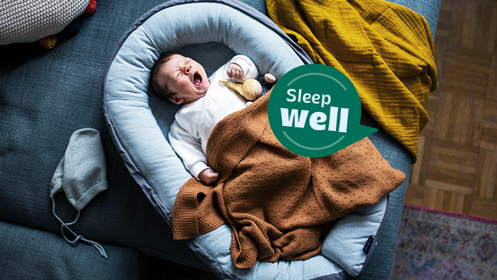 Müdes baby liegt in einem Nestchen