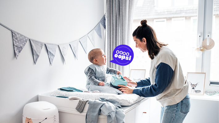 Mutter pflegt ihr Baby auf einer Wickelkommode