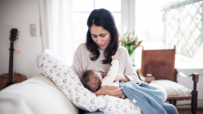 Junge Mutter stillt ihr neugeborenes Baby